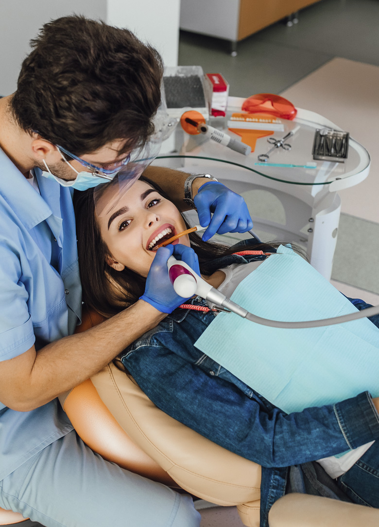 Close up of female dentist looking through dental microscope